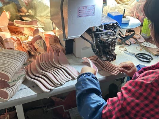Skilled craftsman handcrafting women's shoe soles